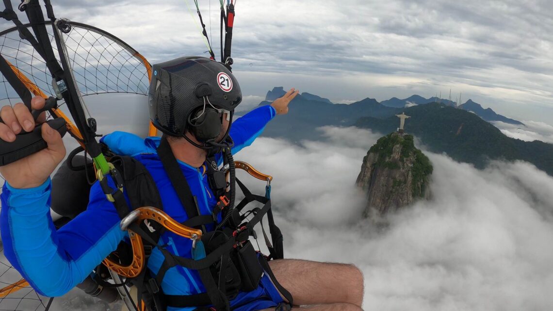 Piloto voando de paramotor em céu aberto